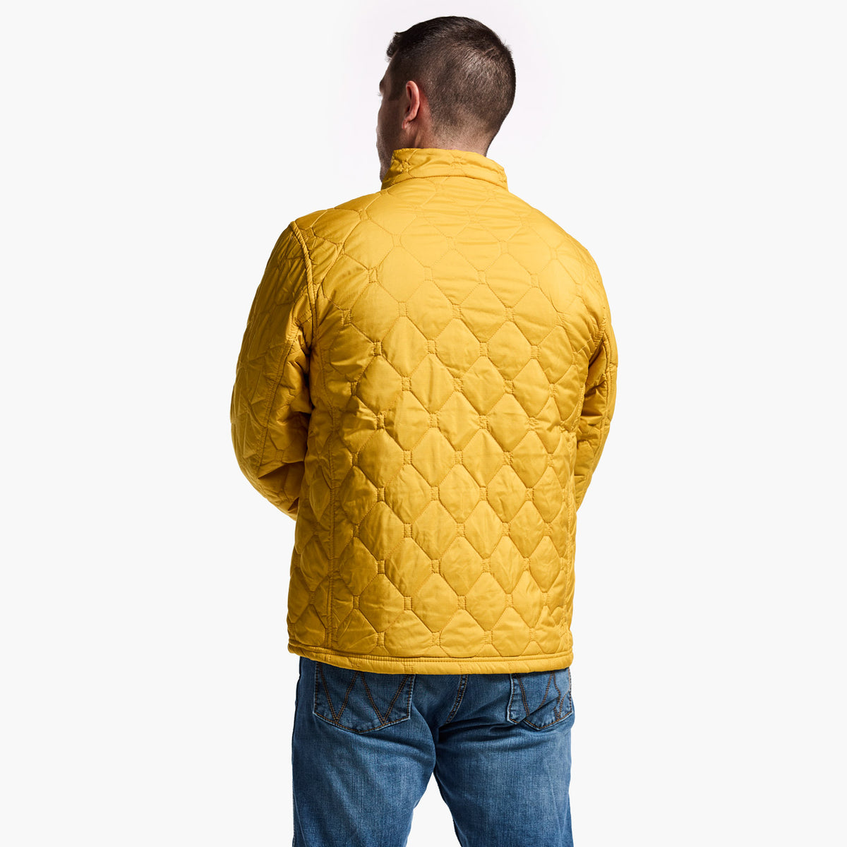 Man wearing a yellow quilted jacket on a white background