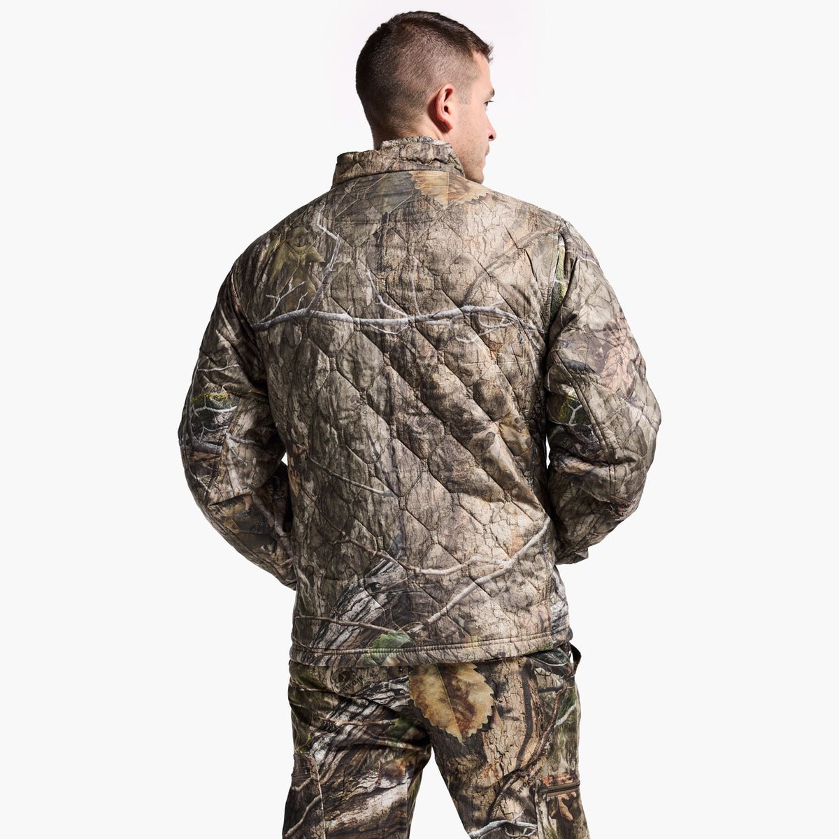 Person wearing a camouflage jacket and pants on a white background