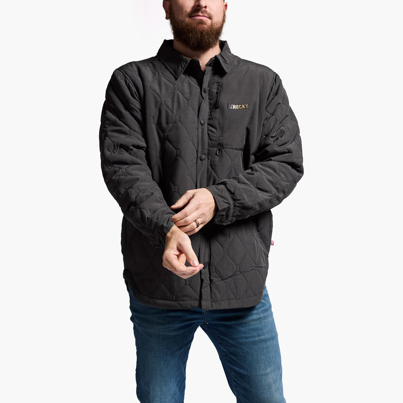 Man wearing a dark gray quilted jacket with a brand logo on a white background
