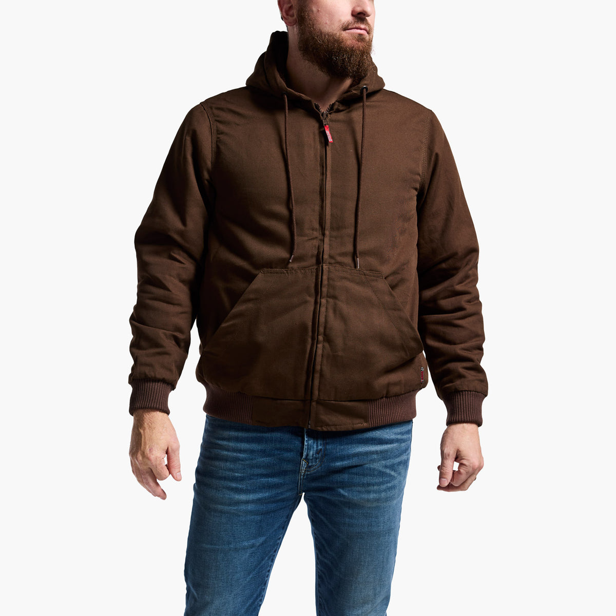 Man wearing a brown hooded jacket and blue jeans on a white background