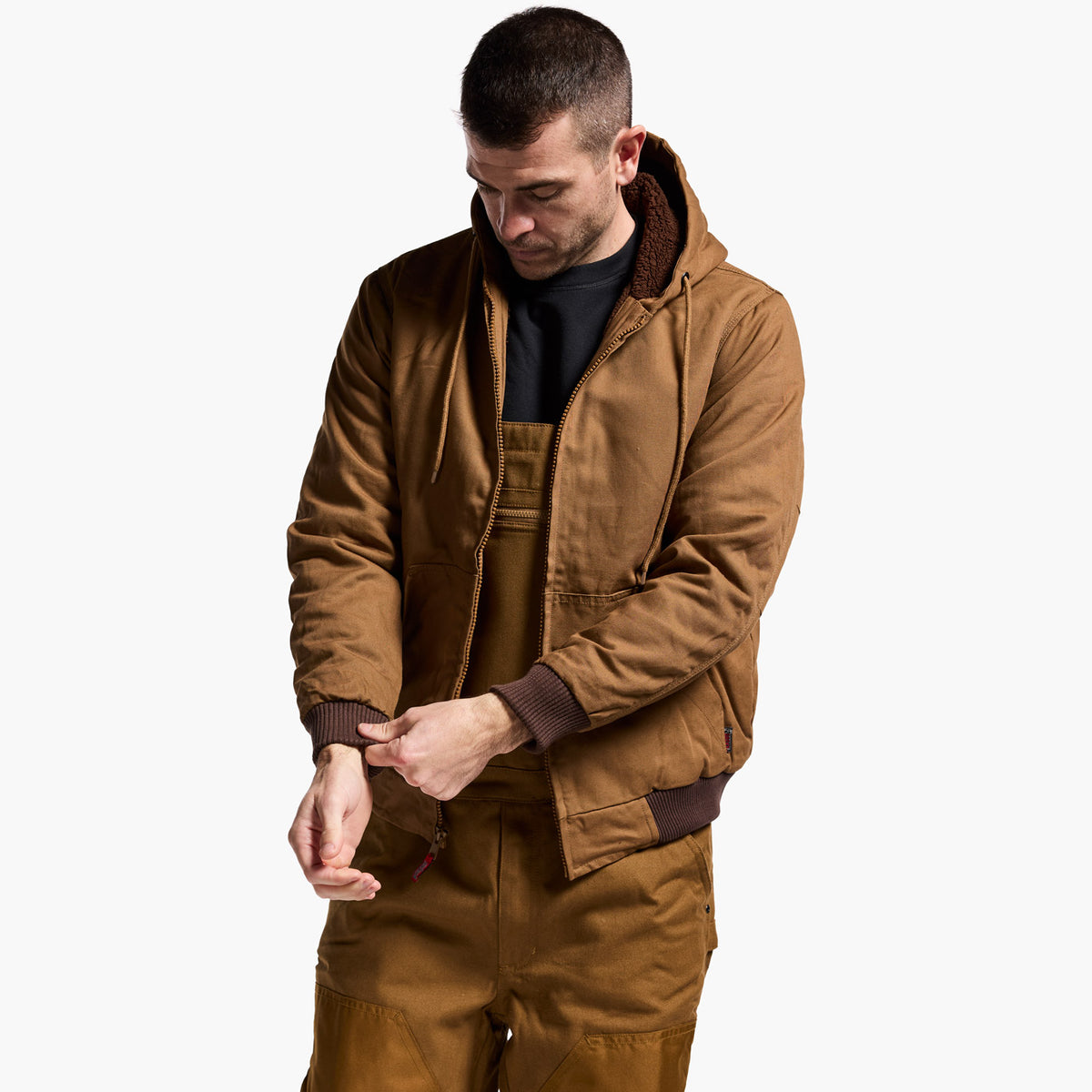 Man wearing a brown jacket and pants on a white background