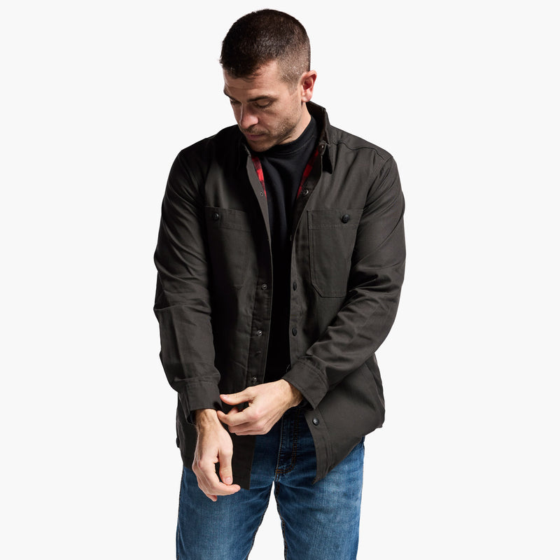 Man wearing a dark jacket and blue jeans on a white background