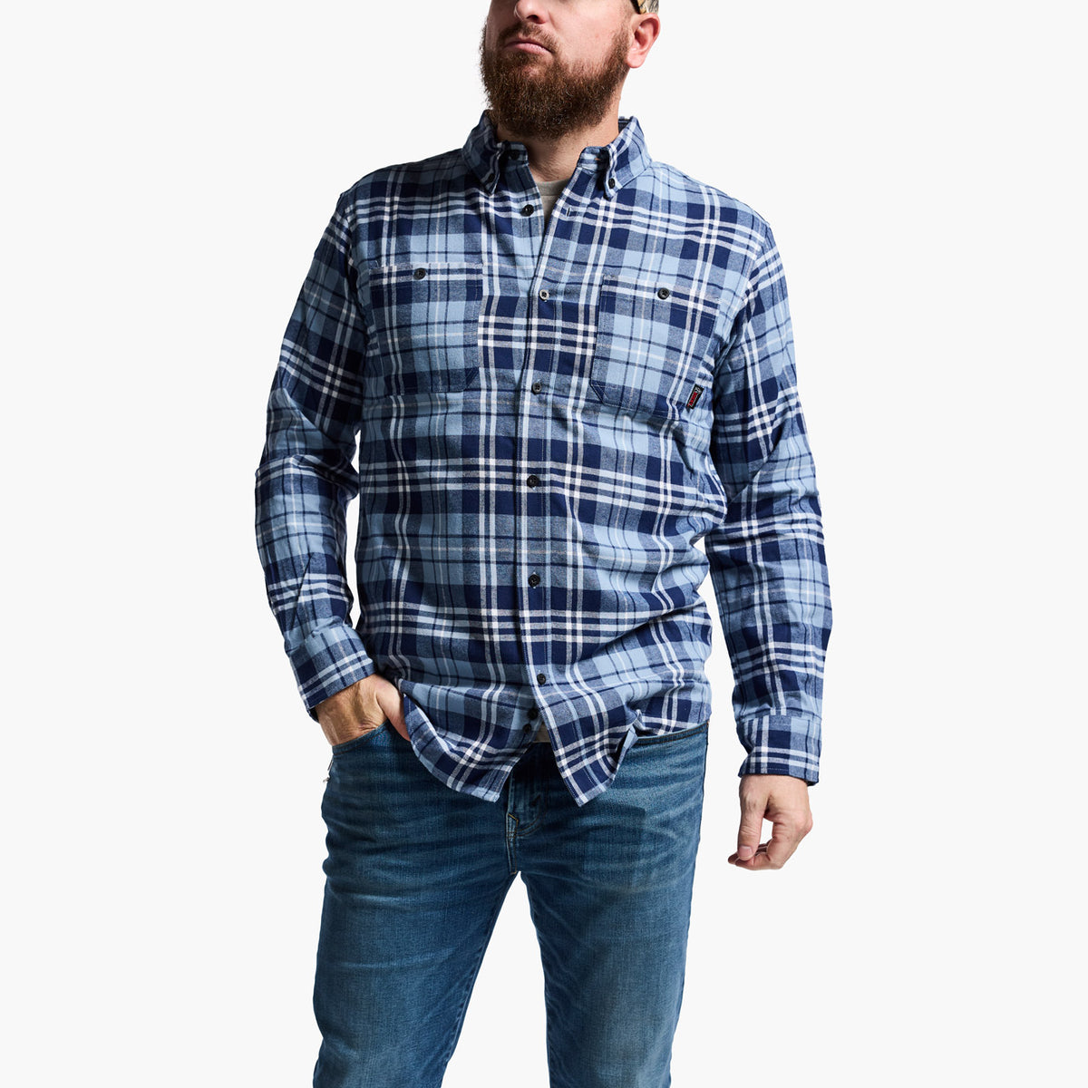 Man wearing a blue plaid shirt and jeans on a white background