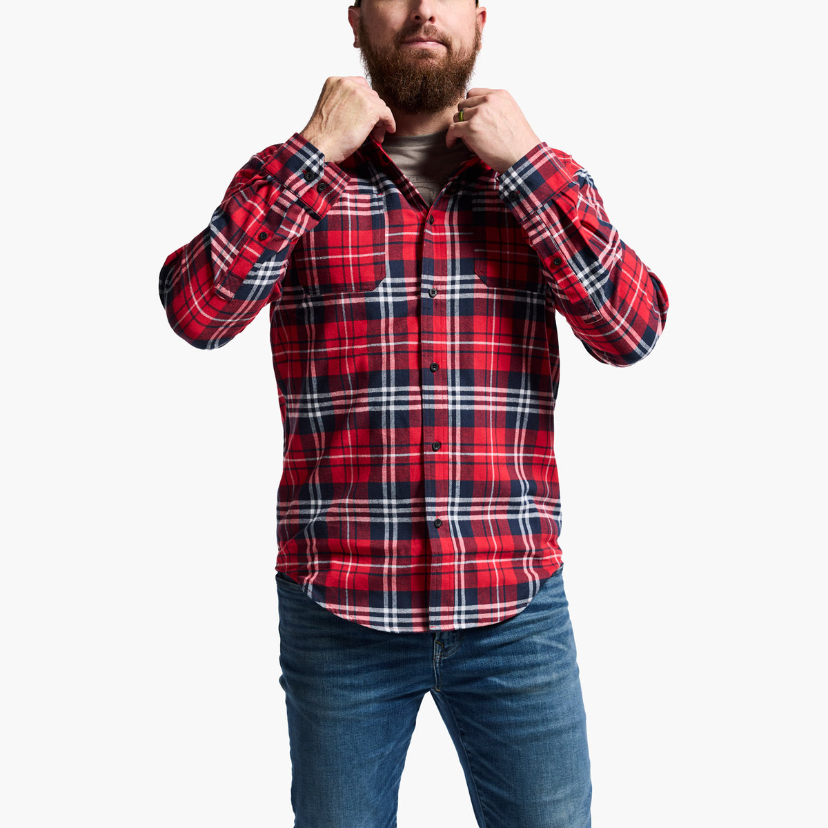 Man wearing a red and blue plaid shirt with rolled-up sleeves on a white background